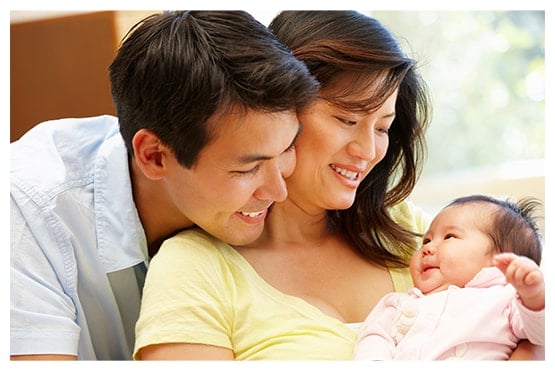 Happy family with baby through surrogacy